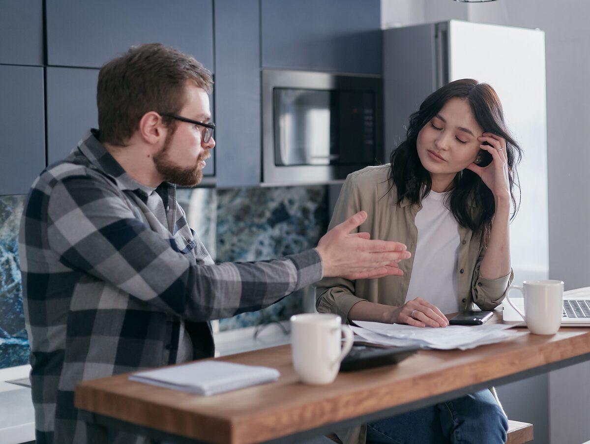 Couple at kitchen table, emotionally disconnected